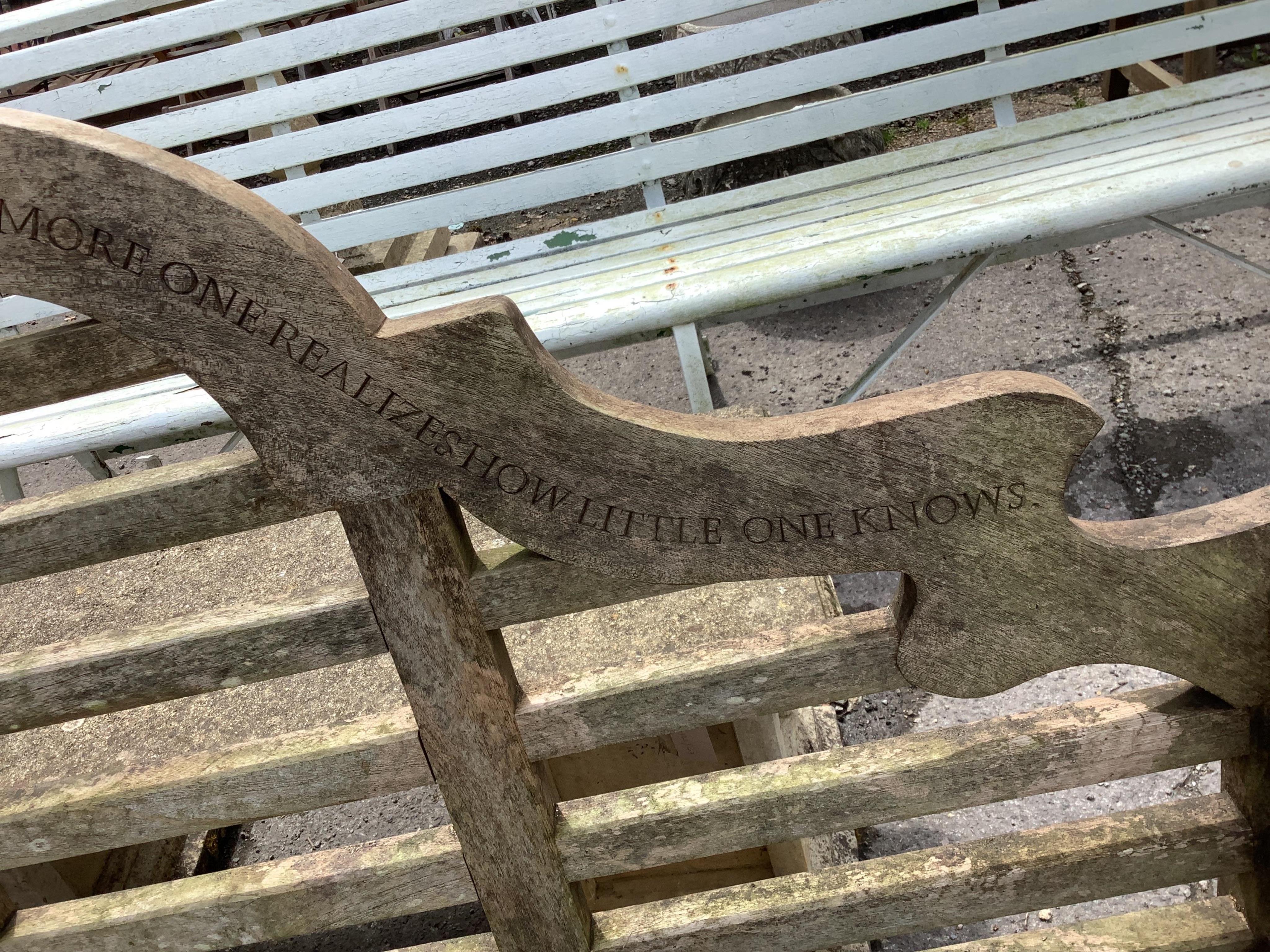 A weathered teak Lutyens style garden bench, with carved inscription, width 55cm, height 106cm